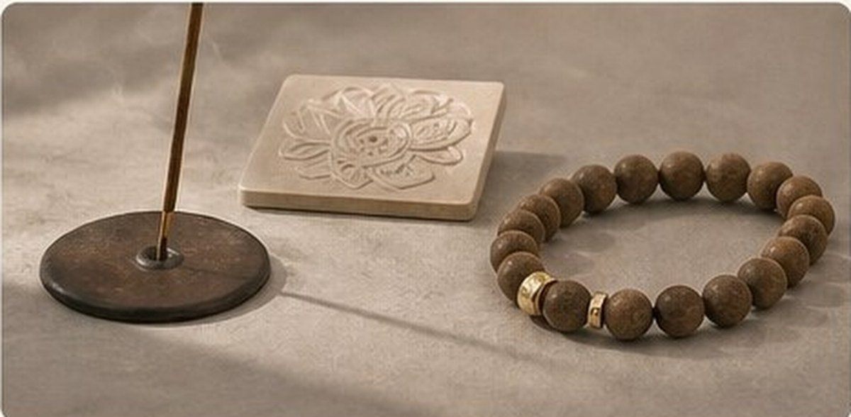 Incense sticks, aromatic wood and scent beads on warm stone